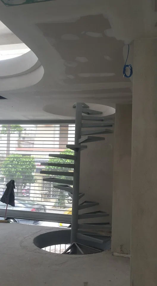 Εσωτερικός χώρος με καμπύλη γύψινη κατασκευή και σκάλα